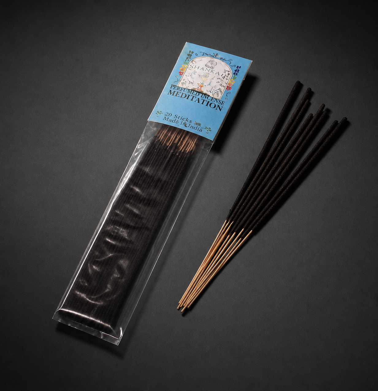 A cellophane package of 7 Chakras stick incense displayed on a flat surface next to loose dark incense sticks,