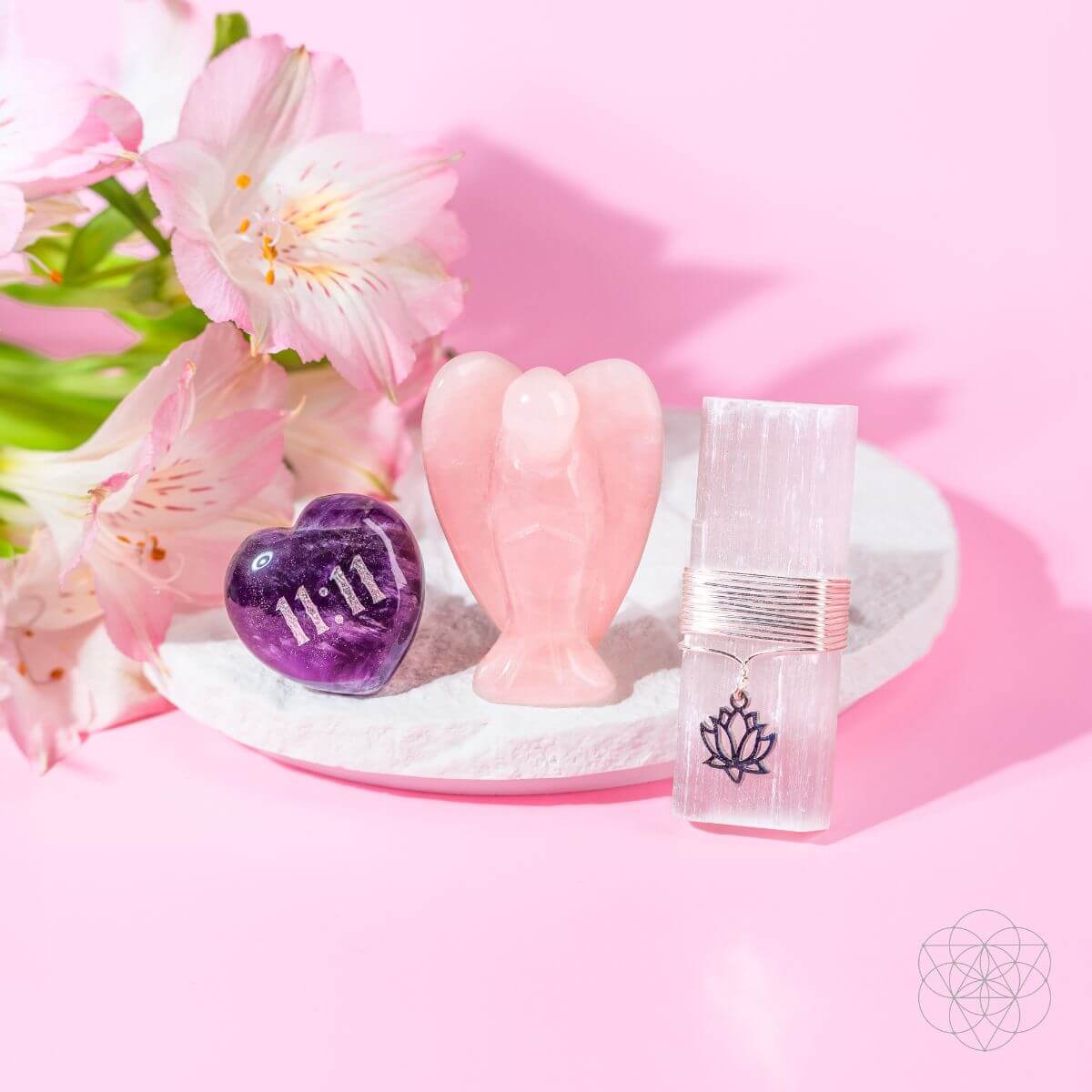 The 11:11 crystal car vent clips displayed elegantly on a white textured plate, surrounded by soft pink flowers on a pink background.