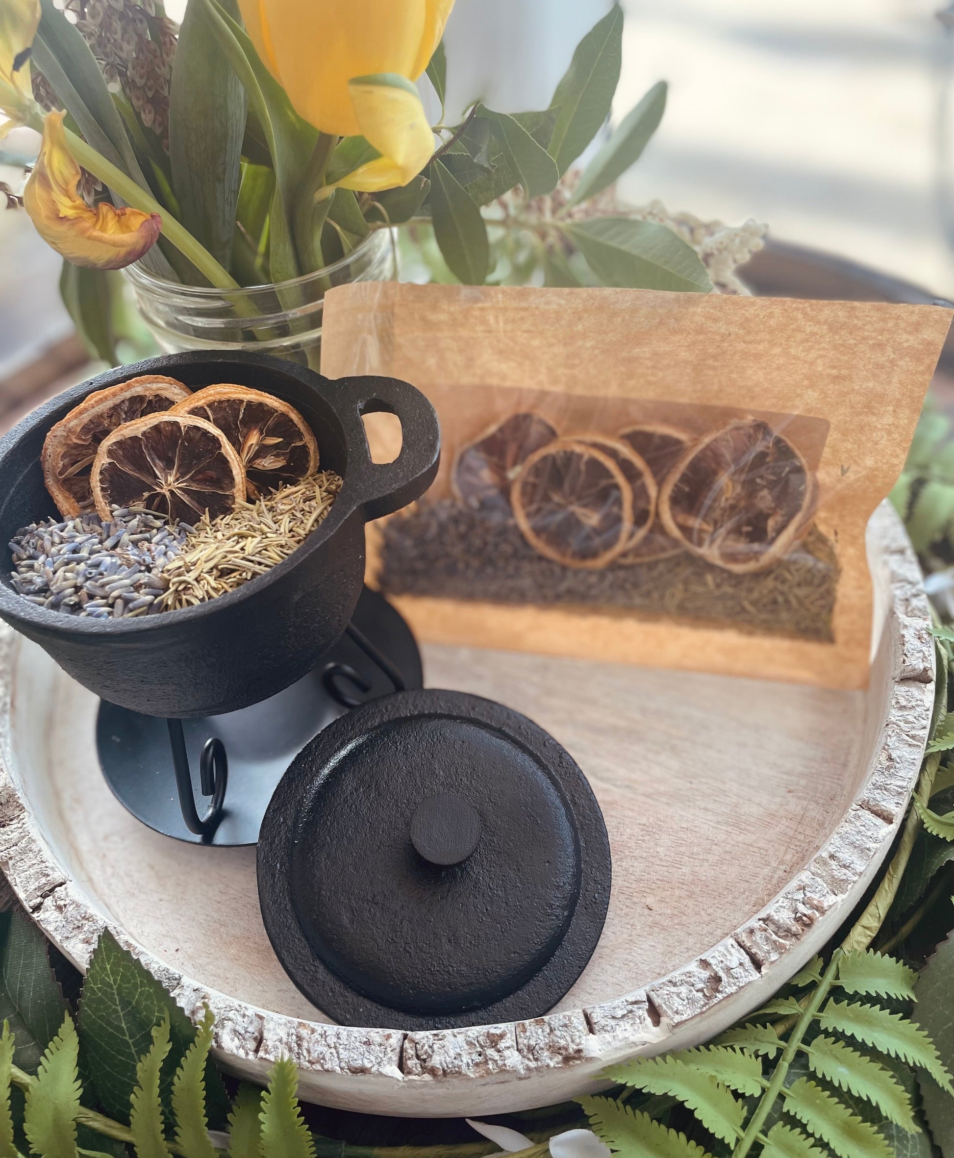 Angled view of the happiness stovetop potpourri blend showcasing the natural floral and citrus ingredients inside the miniature cauldron.