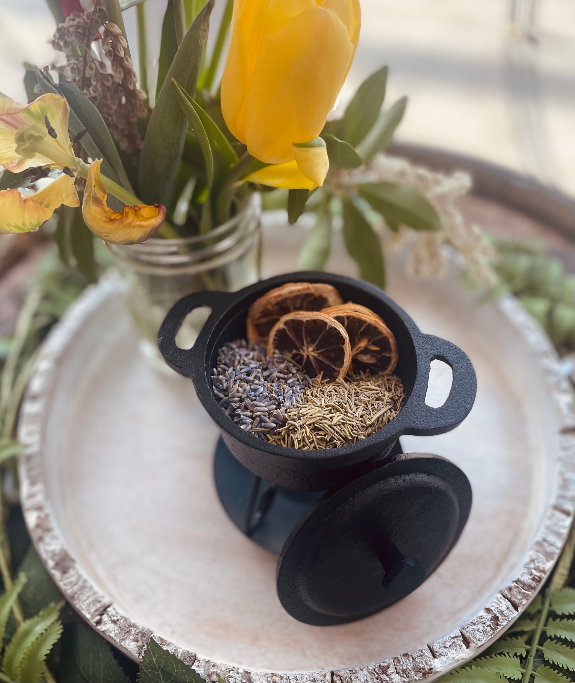 Top-down view of the single-use happiness aromatherapy potpourri kit on a white wooden serving tray surrounded by seasonal flowers.