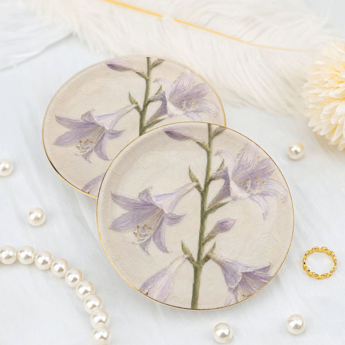 Two round ceramic jewelry trays featuring a purple lavender bellflower design and a gold rim styled on a white background with pearls.