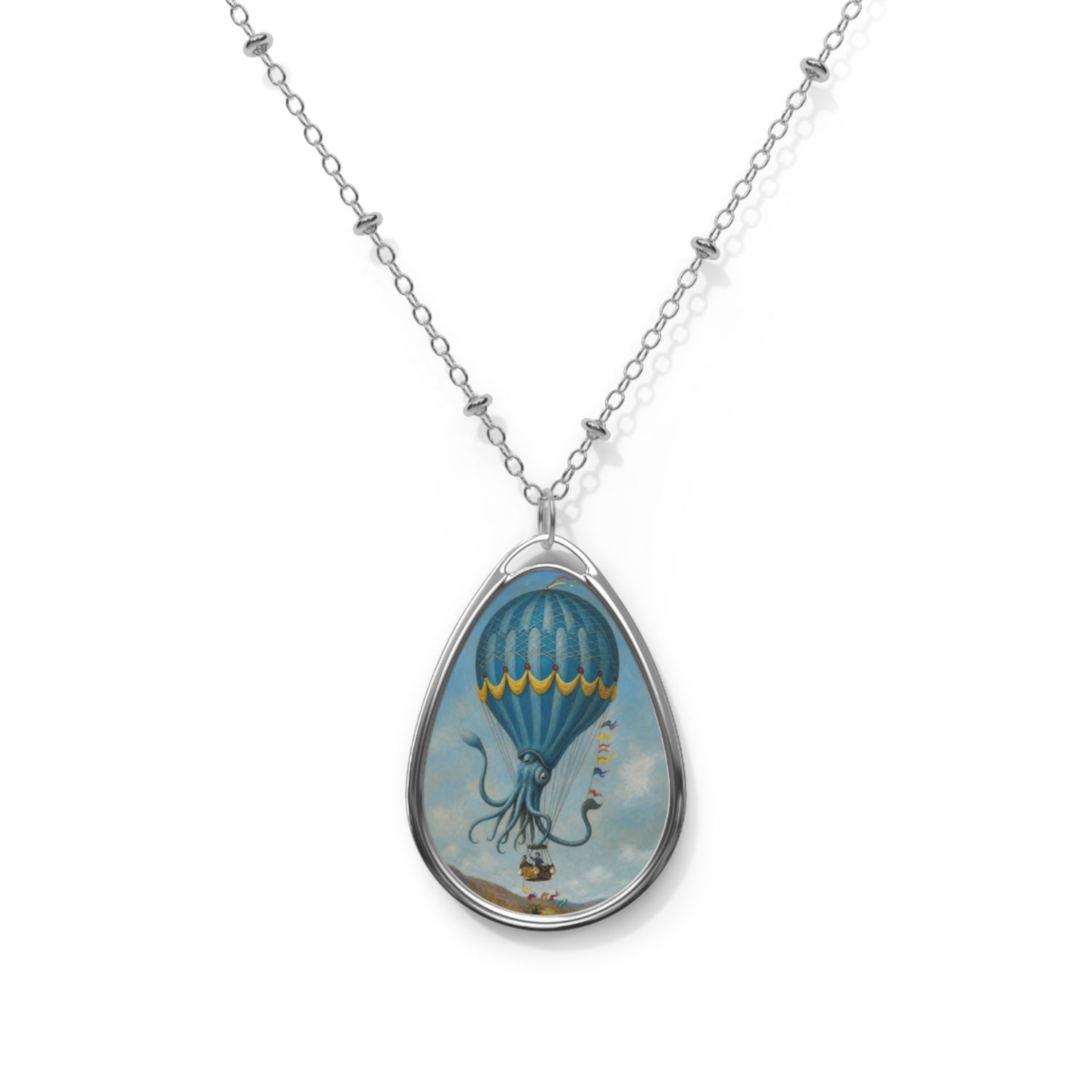 Front view of a silver teardrop pendant necklace featuring a surreal blue octopus hot air balloon floating in a cloudy sky.