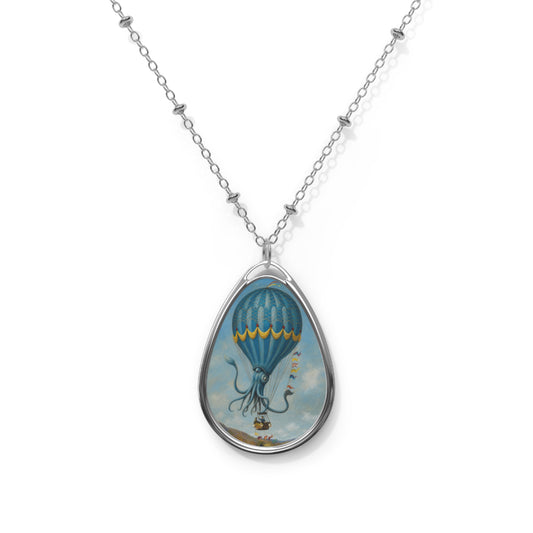 Front view of a silver teardrop pendant necklace featuring a surreal blue octopus hot air balloon floating in a cloudy sky.